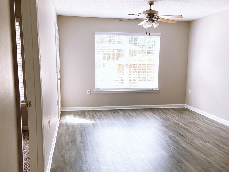 empty apartment living room with wood-look flooring at Crescent Commons in Fayetteville NC